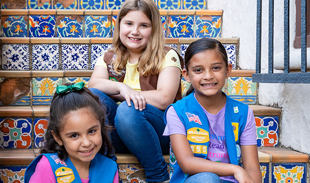 Two Girl Scout Daisies and one Girl Scout Brownie sitting on mosaic-decorated stairs