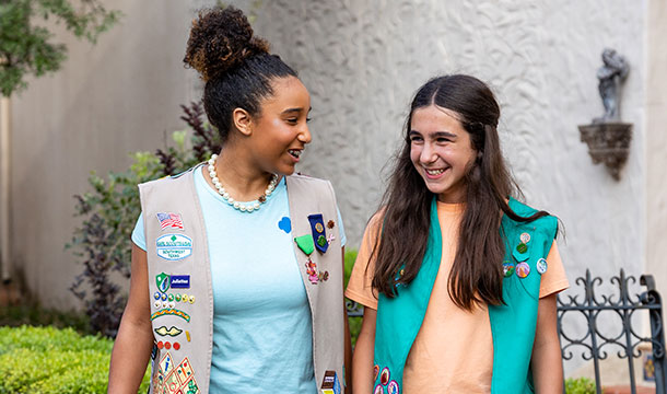 Two girl scouts smiling at each other
