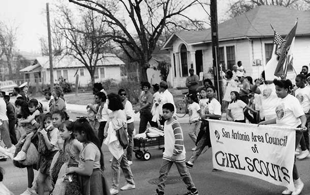 1990s image of girl scouts marching in the streets