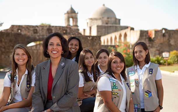 Patricia Diaz Dennis, the first Latina elected as chair of the National Board in 2005, posing at the missions with girl scouts