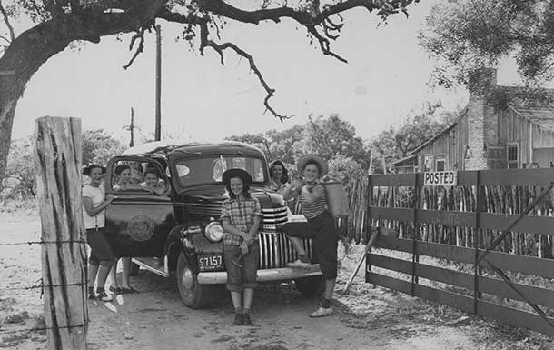 1940s image of girl scouts posing next to a car