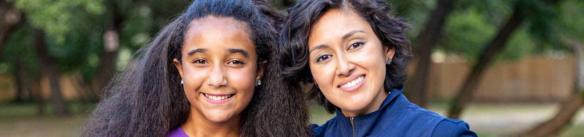  adult woman girl scout volunteer standing with a girl scout smiling 