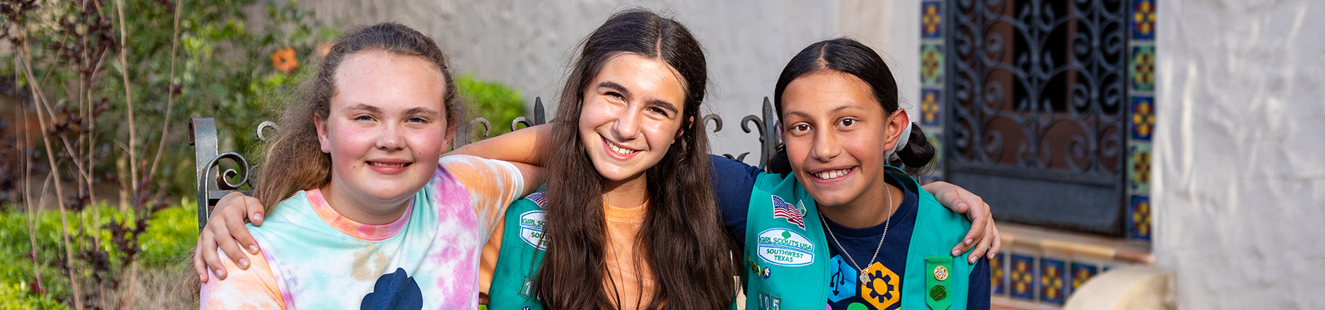  group of girl scouts walking outside smiling at camera 