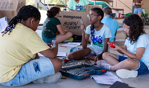 girls sitting on the floor using tools